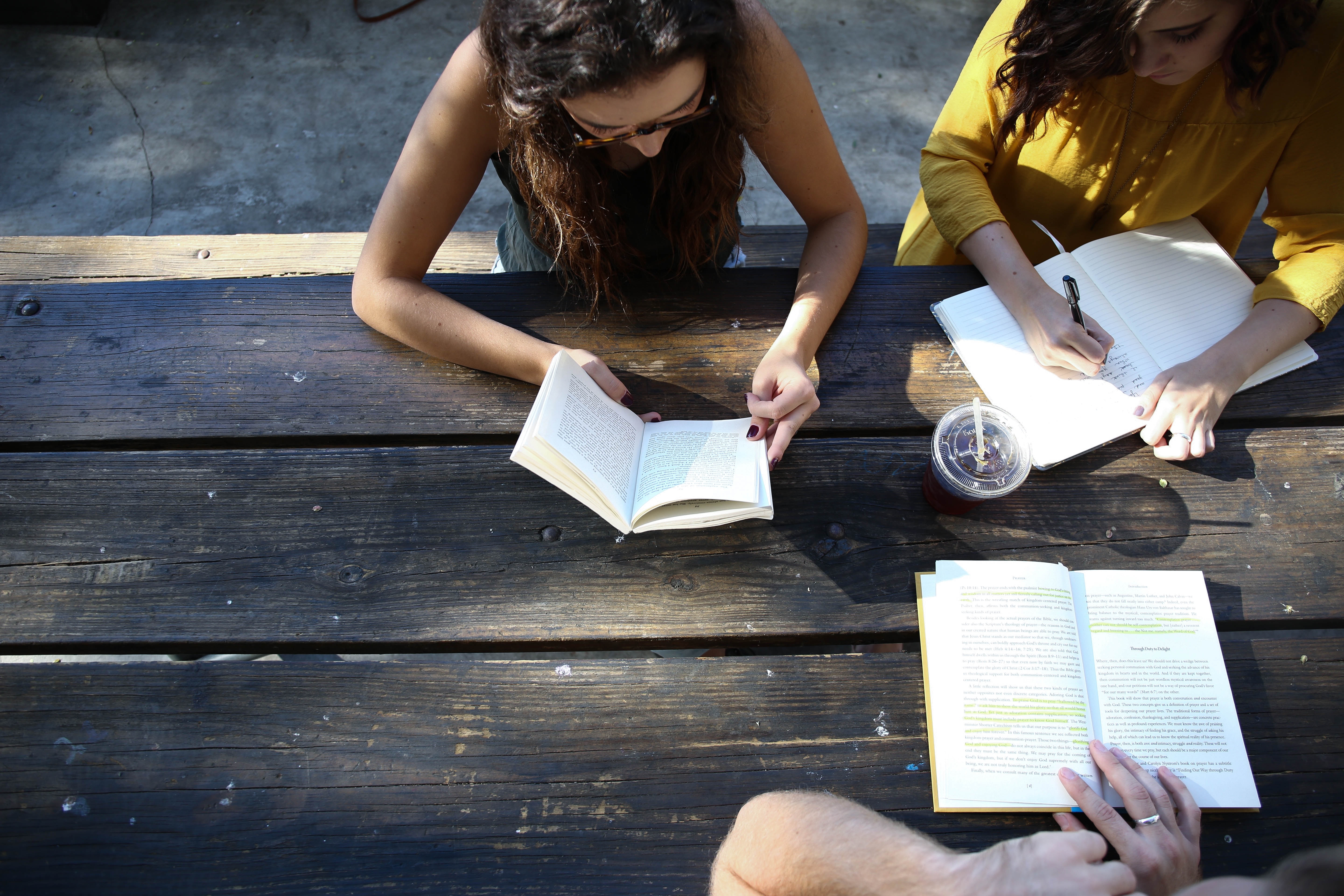 women sitting at a table sharing notes from their journal