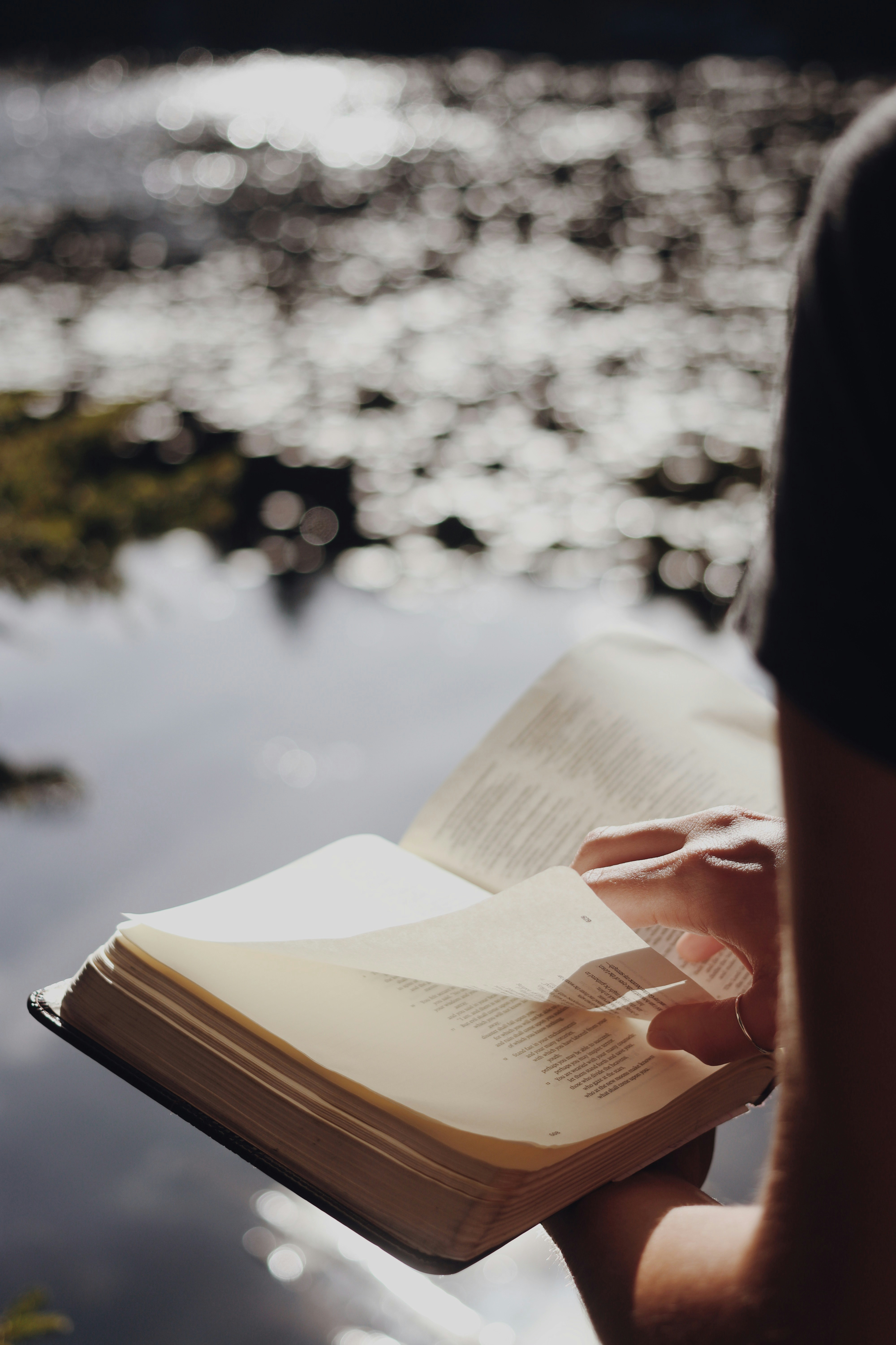 woman reading the Bible by a lake