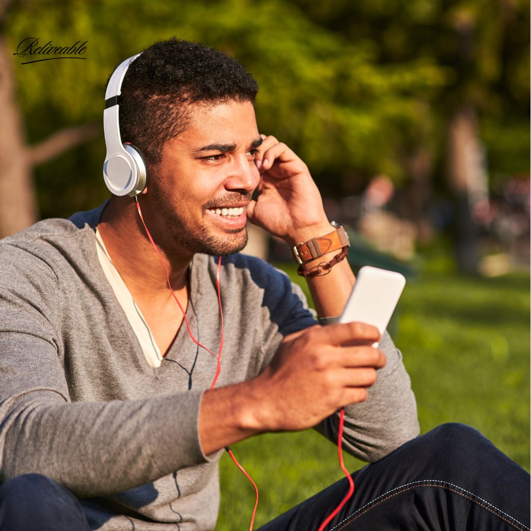 A person interacting to a ReLiveable interactive voice memorial, smiling as they hear their loved one’s voice.