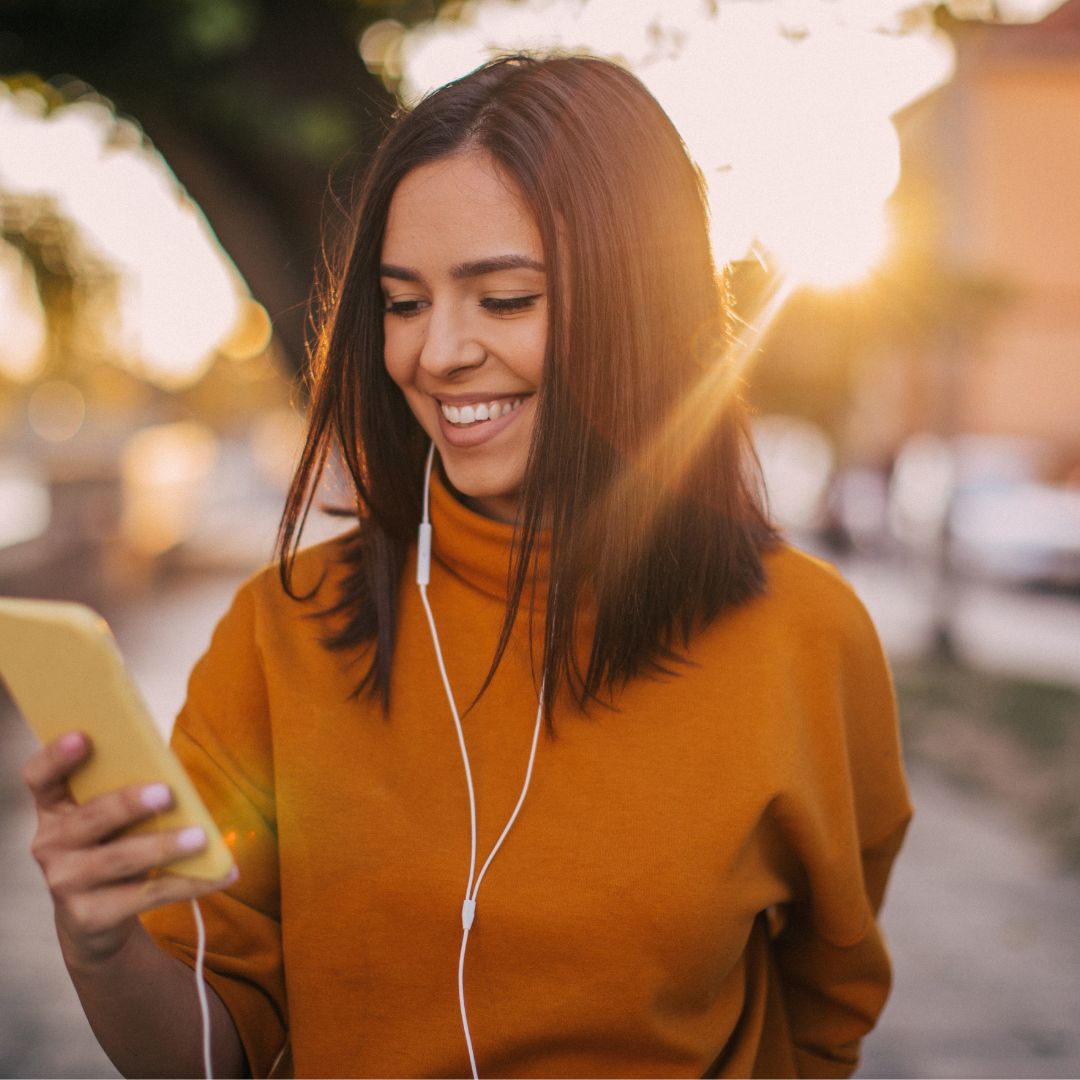 A woman laughs while listening to a humorous Interactive Voice Memorial from ReLiveable’s AI conversational technology.