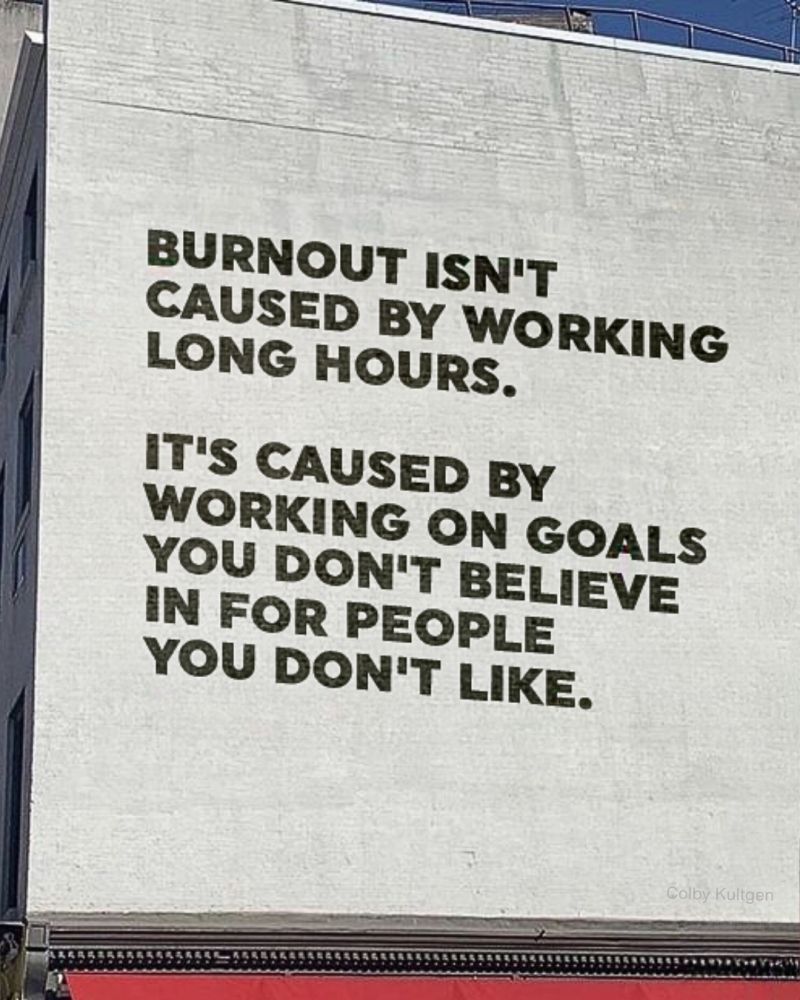 A quote painted on a wall that reads: "BURNOUT ISN'T CAUSED BY WORKING LONG HOURS. IT'S CAUSED BY WORKING ON GOALS YOU DON'T BELIEVE IN FOR PEOPLE YOU DON'T LIKE. - Colby Kultgen