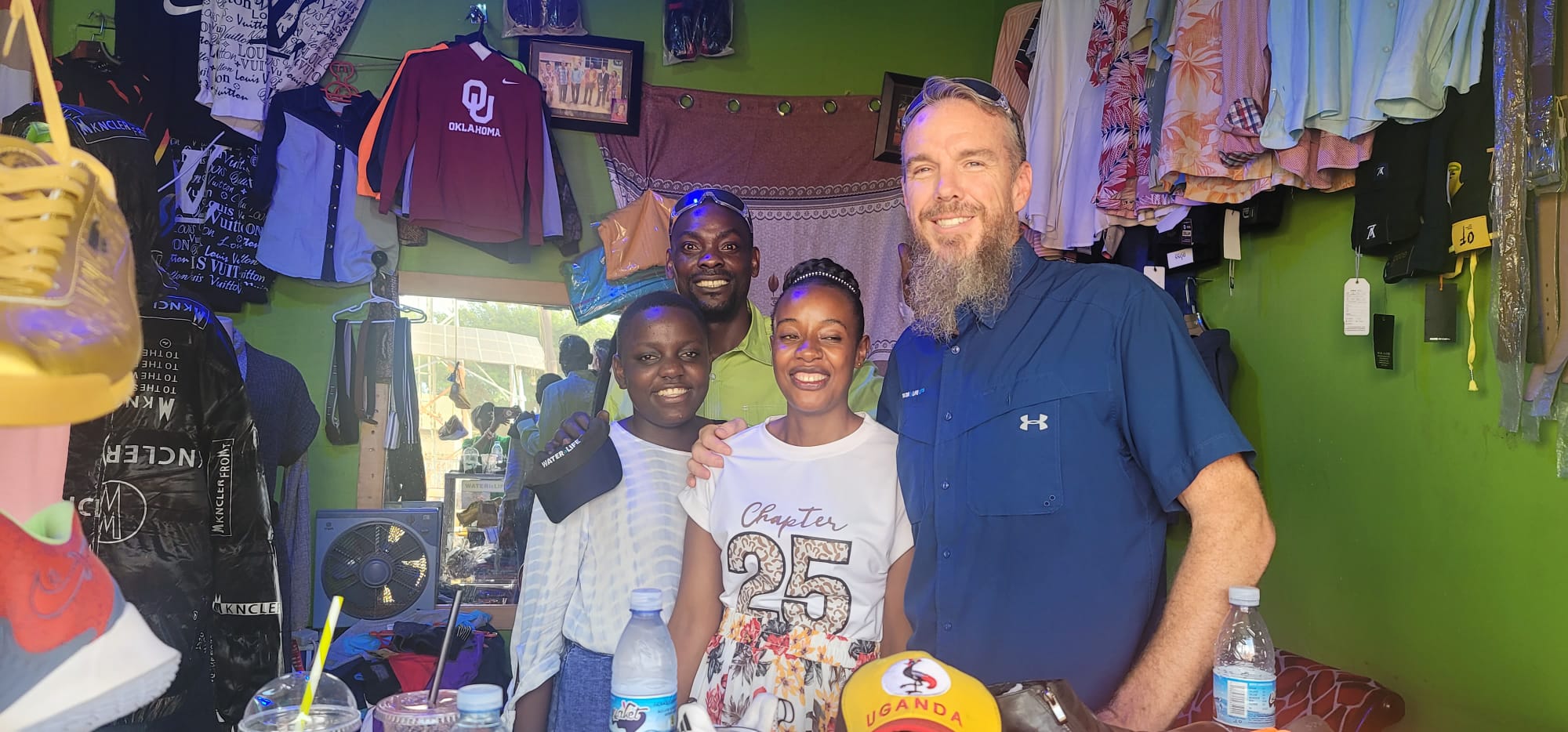 Asian woman wrapped in a thick knitted blanket holding a steaming cup of tea by the window.