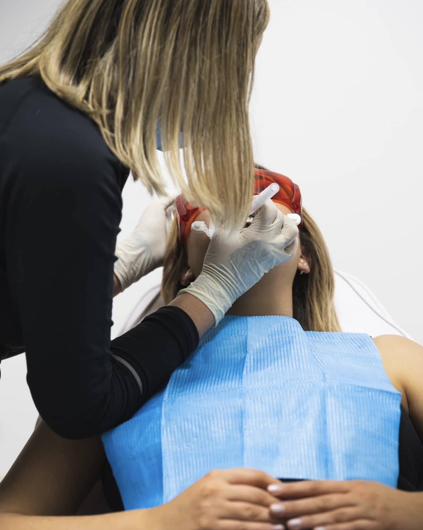 Professional checking teeth of whitening patient