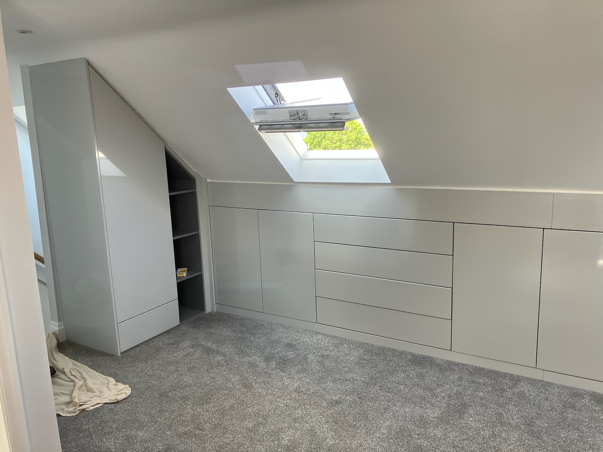Bespoke fitted angled loft wardrobe storage in yorkshire with handleless doors in modern high gloss Bespoke fitted angled loft wardrobe storage in yorkshire with handleless doors in modern high gloss