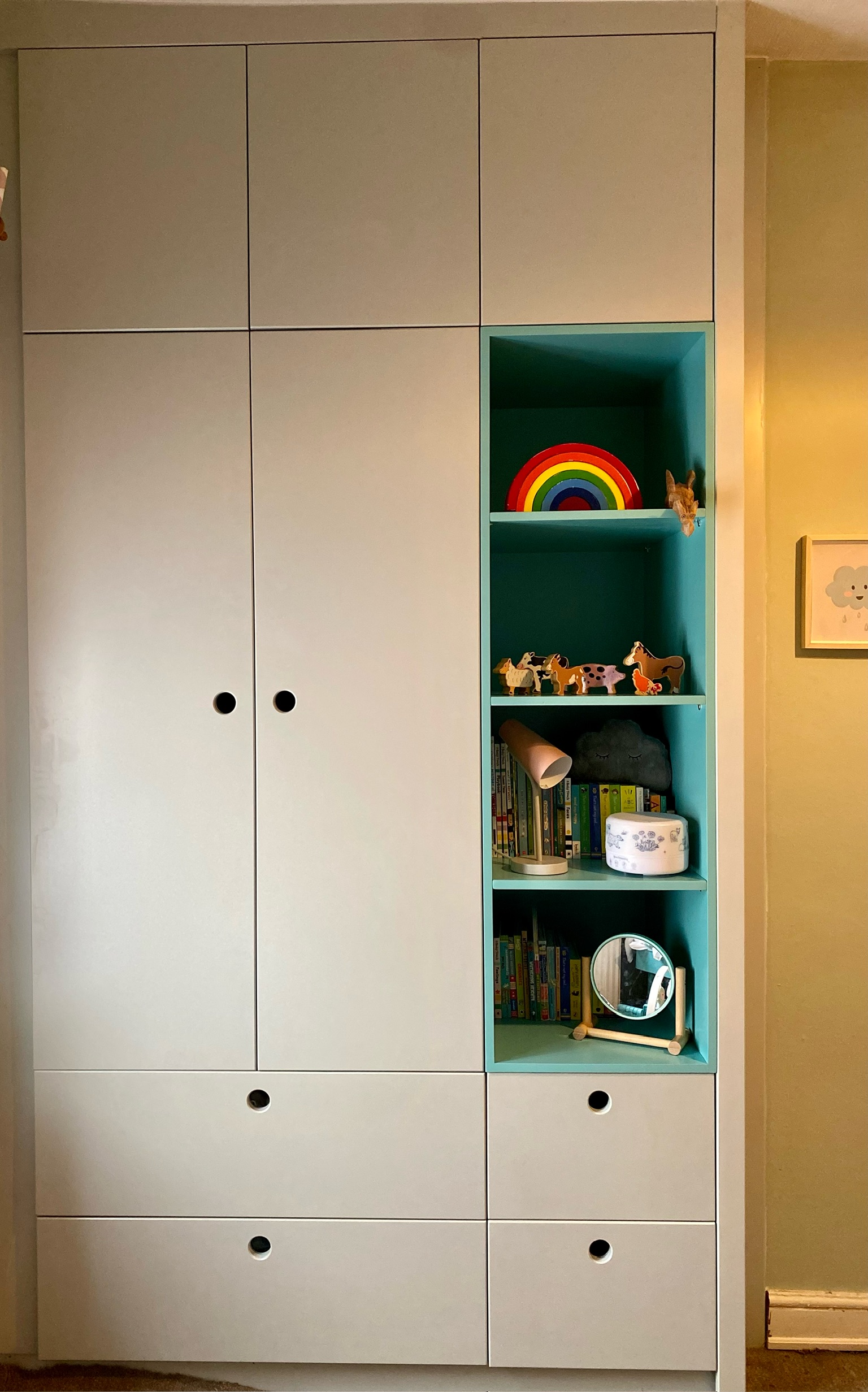 Bespoke handleless fitted wardrobe in child's bedroom with shelves in a contrasting colour Bespoke handleless fitted wardrobe in child's bedroom with shelves in a contrasting colour