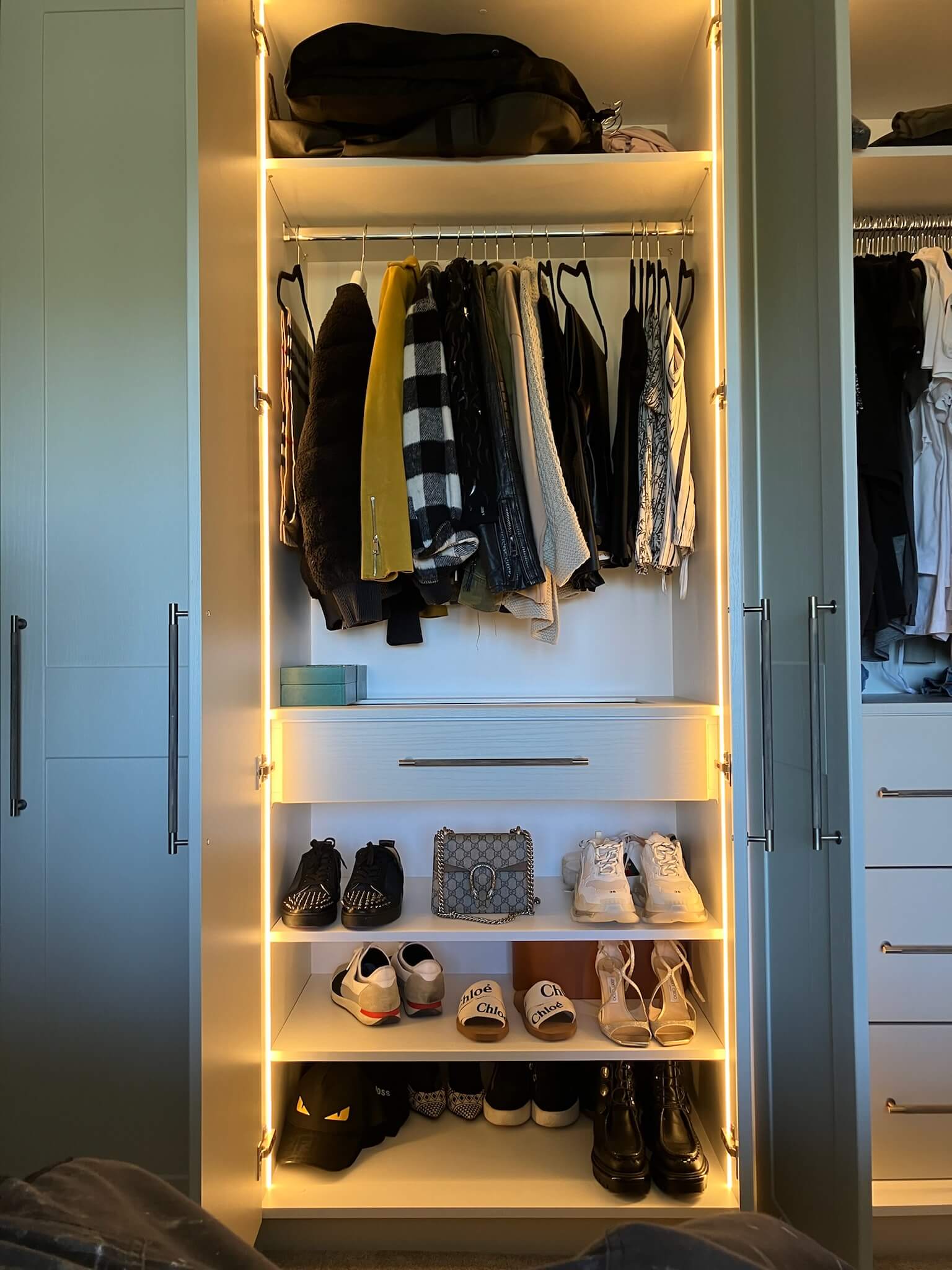 Custom fitted wardrobe interior with motion-sensor LED lighting and organised drawer compartments Custom fitted wardrobe interior with motion-sensor LED lighting and organised drawer compartments