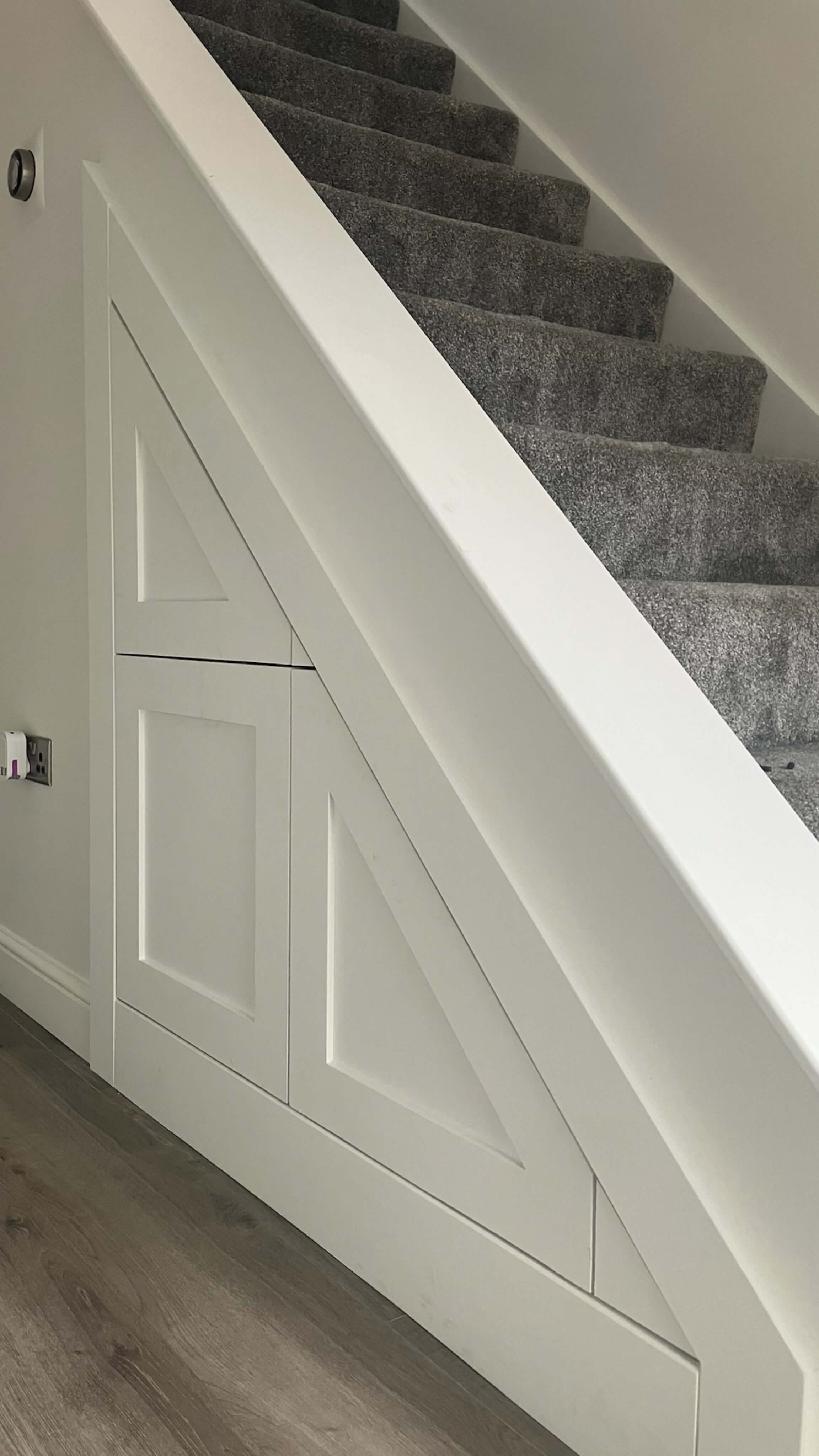 Custom under-stairs storage solution featuring shaker-style push-to-open drawers, handcrafted by JAX Bespoke to maximize unused hallway space with seamless integration and modern functionality Custom under-stairs storage solution featuring shaker-style push-to-open drawers, handcrafted by JAX Bespoke to maximize unused hallway space with seamless integration and modern functionality