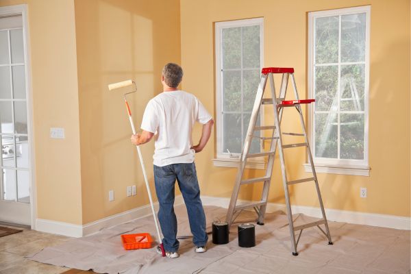 man holding a paint roller man holding a paint roller
