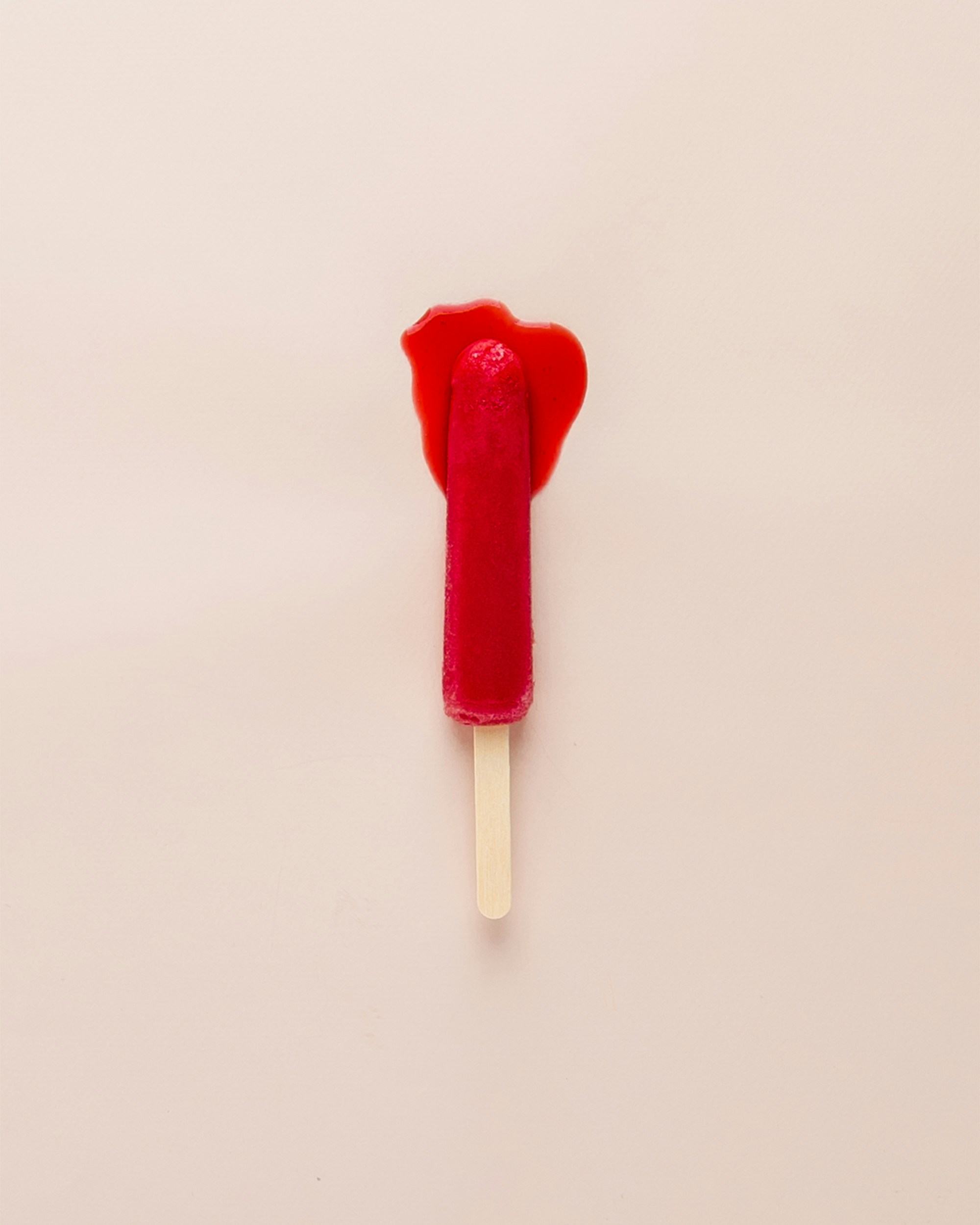 A bright red popsicle is melting