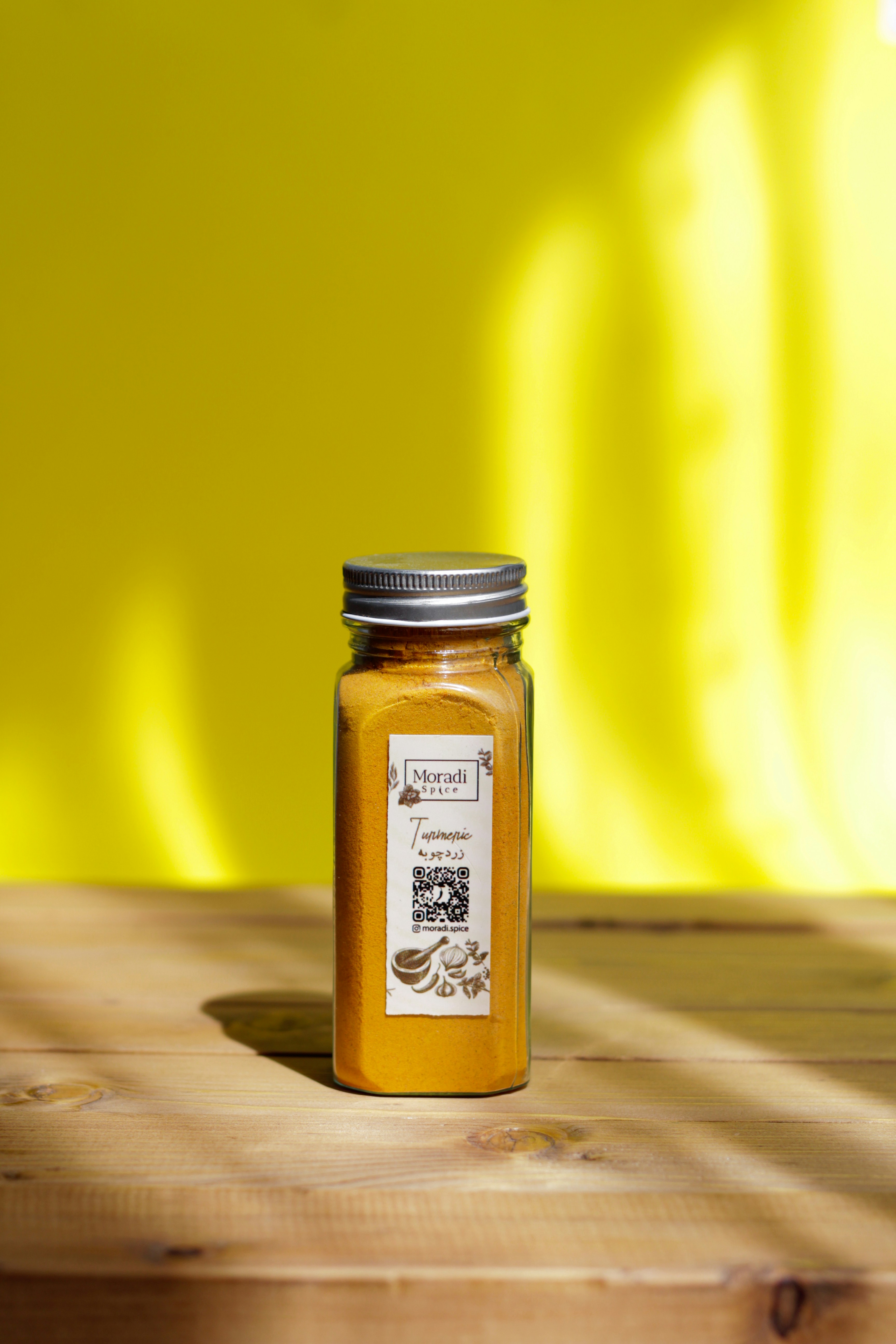 Orange turmeric powder is inside a glass jar