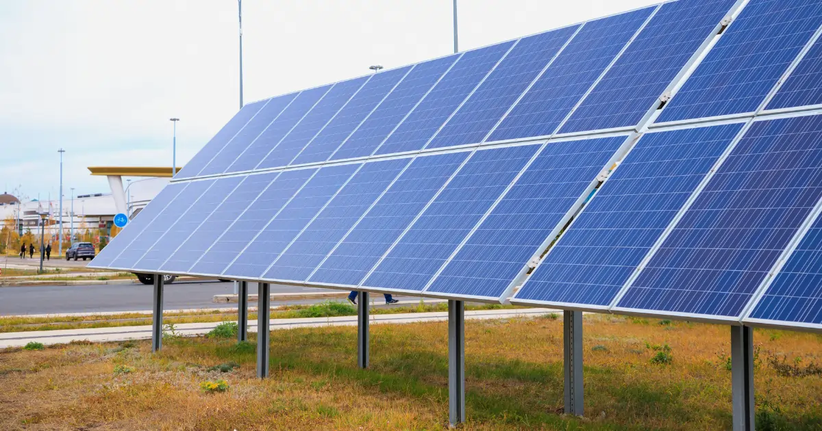 Ground-mounted solar panels installed on a field adjacent to a road. Ground-mounted solar panels installed on a field adjacent to a road.