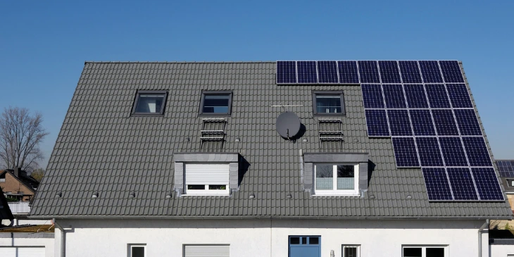 A modern semi-detached house with solar panels fitted on it