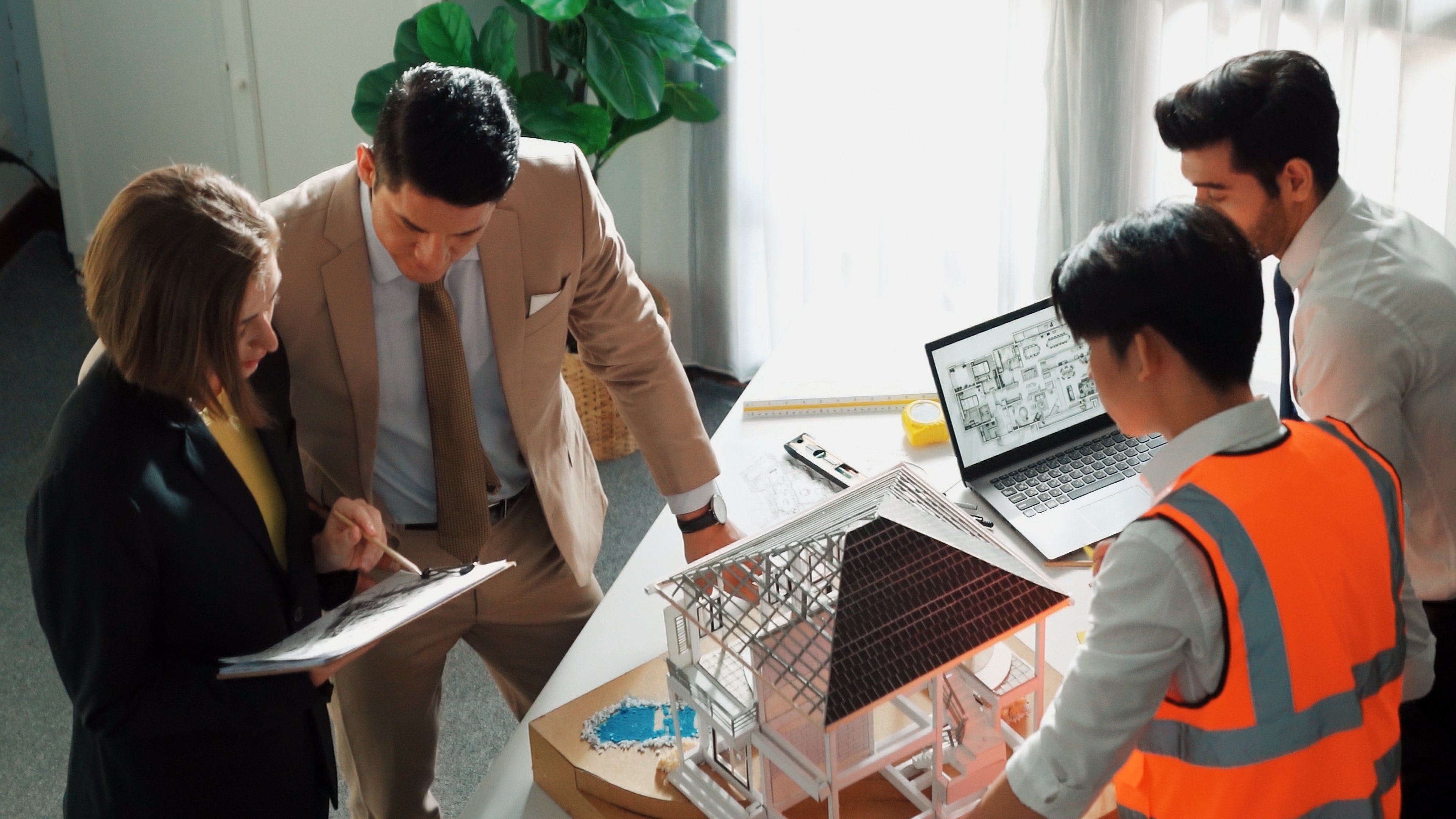 Construction site with project manager and client reviewing plans - repeat business construction Construction site with project manager and client reviewing plans - repeat business construction