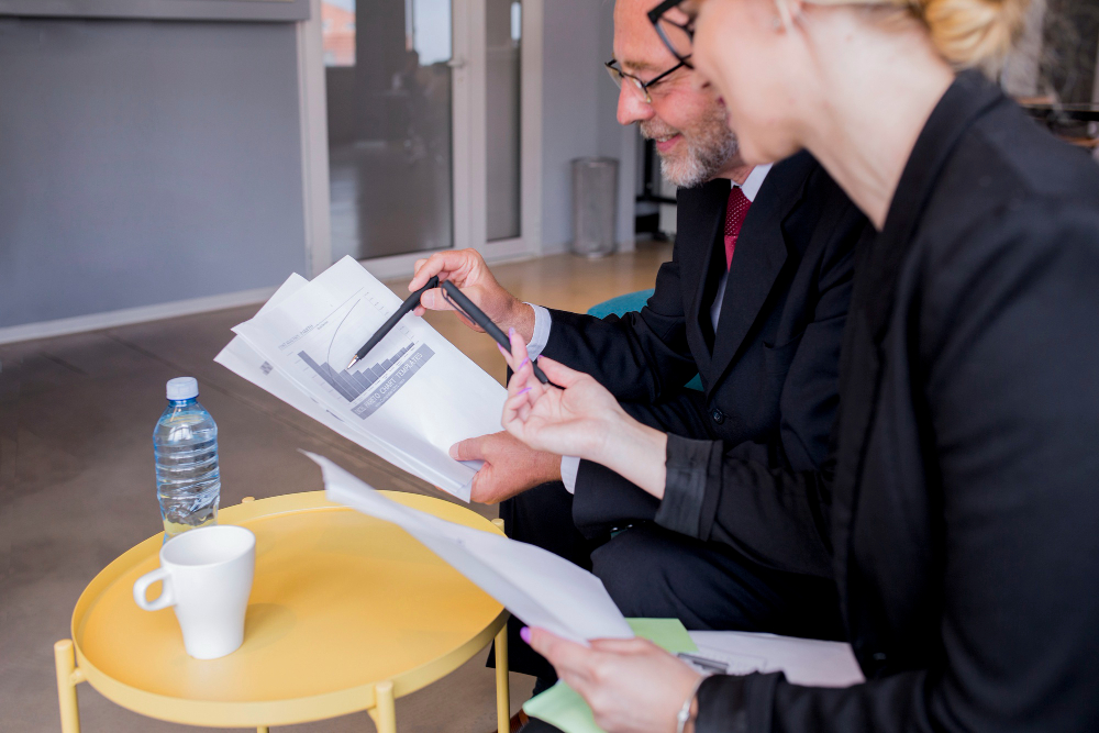 Construction coach and contractor discussing contract terms with highlighted clauses like escalation and inflation adjustments Construction coach and contractor discussing contract terms with highlighted clauses like escalation and inflation adjustments