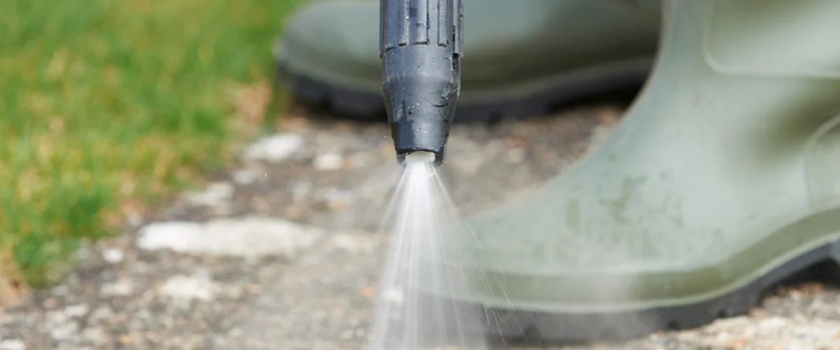 Professional pressure washing cleaning dirt and grime off a driveway surface