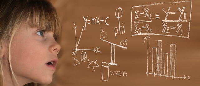 image of a young girl looking over a math problem at the blackboard
