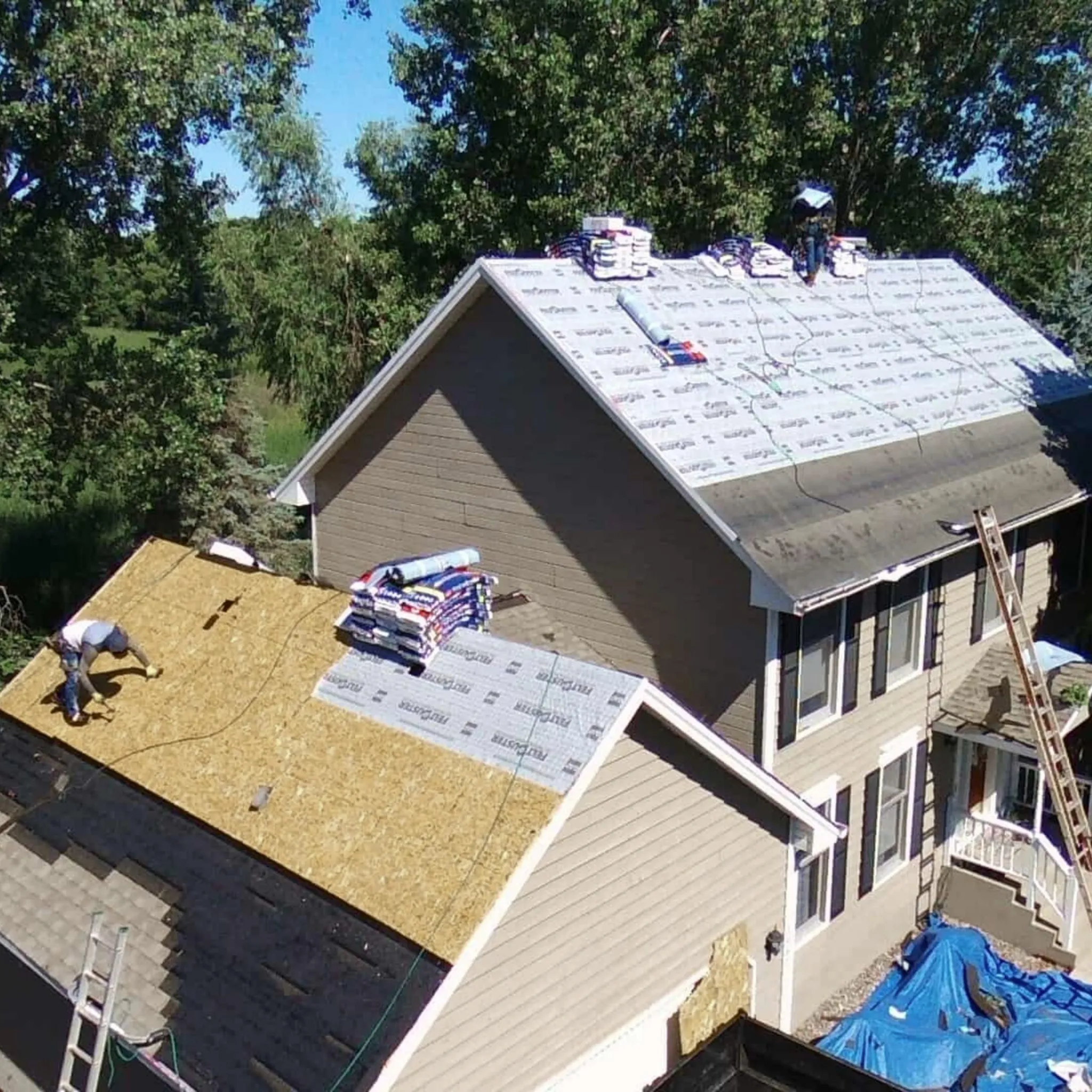 A roofer inspecting a roof for hail damage.