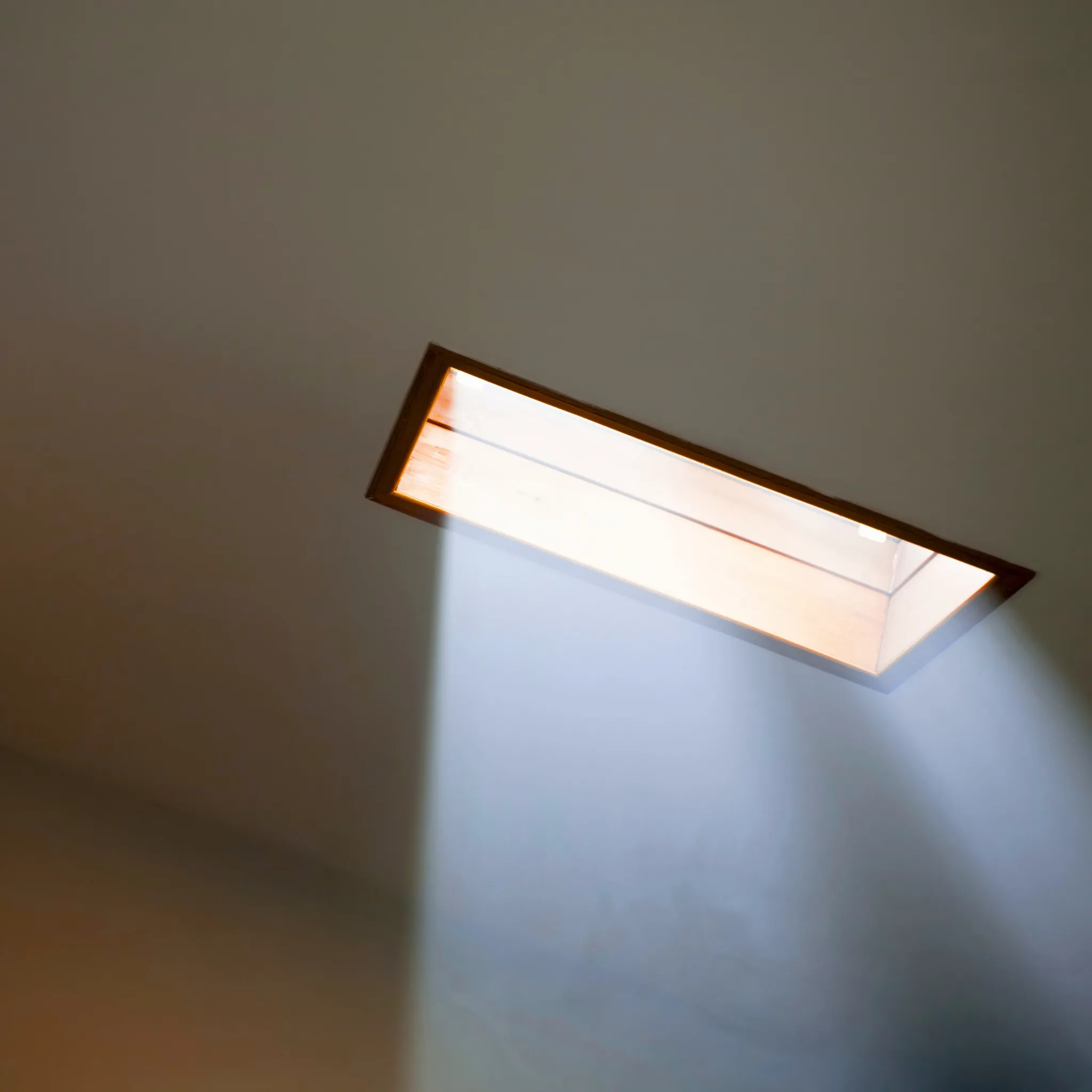A professional repairing a skylight on a modern roof.