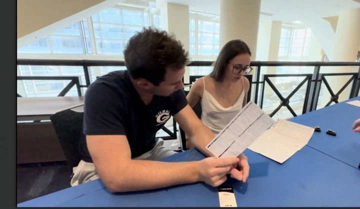 Two individuals reading a paper Two individuals reading a paper