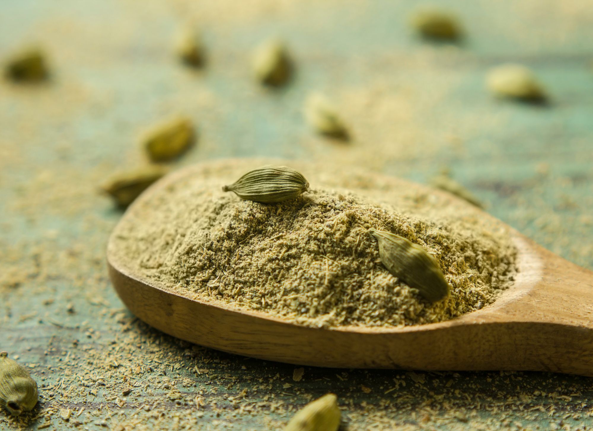 cardamom powder on wooden spoon
