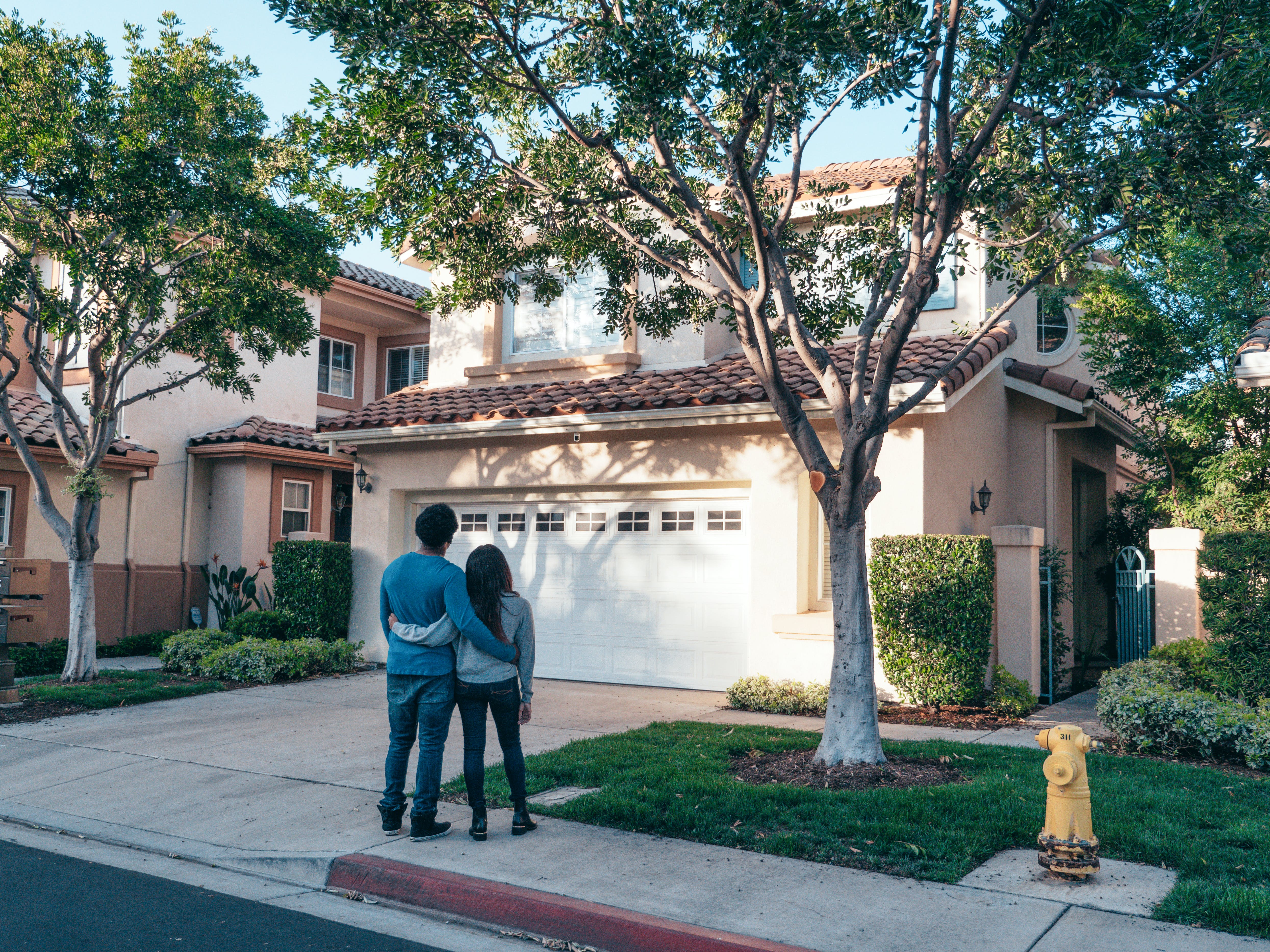 Young couple standing in fron of their new home