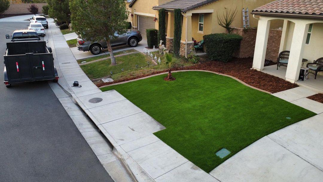 Artificial turf installed in a front yard in a residential neighborhood, offering a neat and eco-friendly lawn solution for homeowners in the Inland Empire Artificial turf installed in a front yard in a residential neighborhood, offering a neat and eco-friendly lawn solution for homeowners in the Inland Empire
