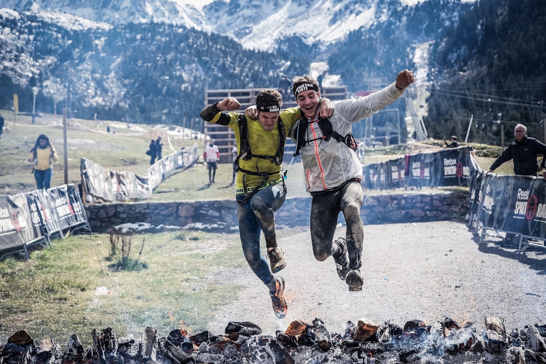 obstacle racers jumping in a puddle obstacle racers jumping in a puddle