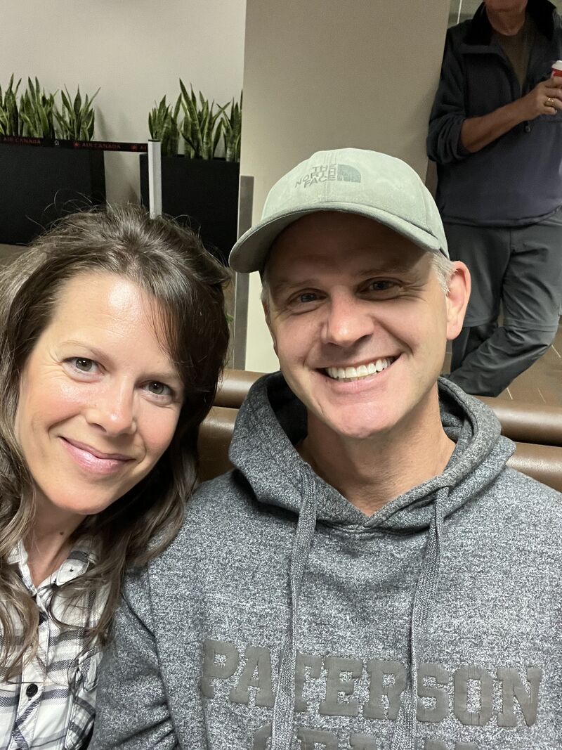 Stacey Olson and husband sitting at the airport