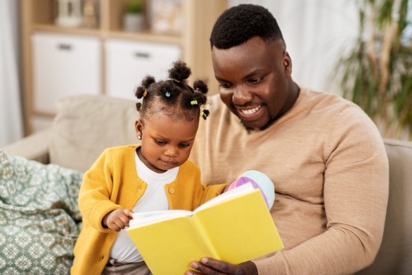A father reading to his young daughter -  Impact of Childcare on Early Language Development