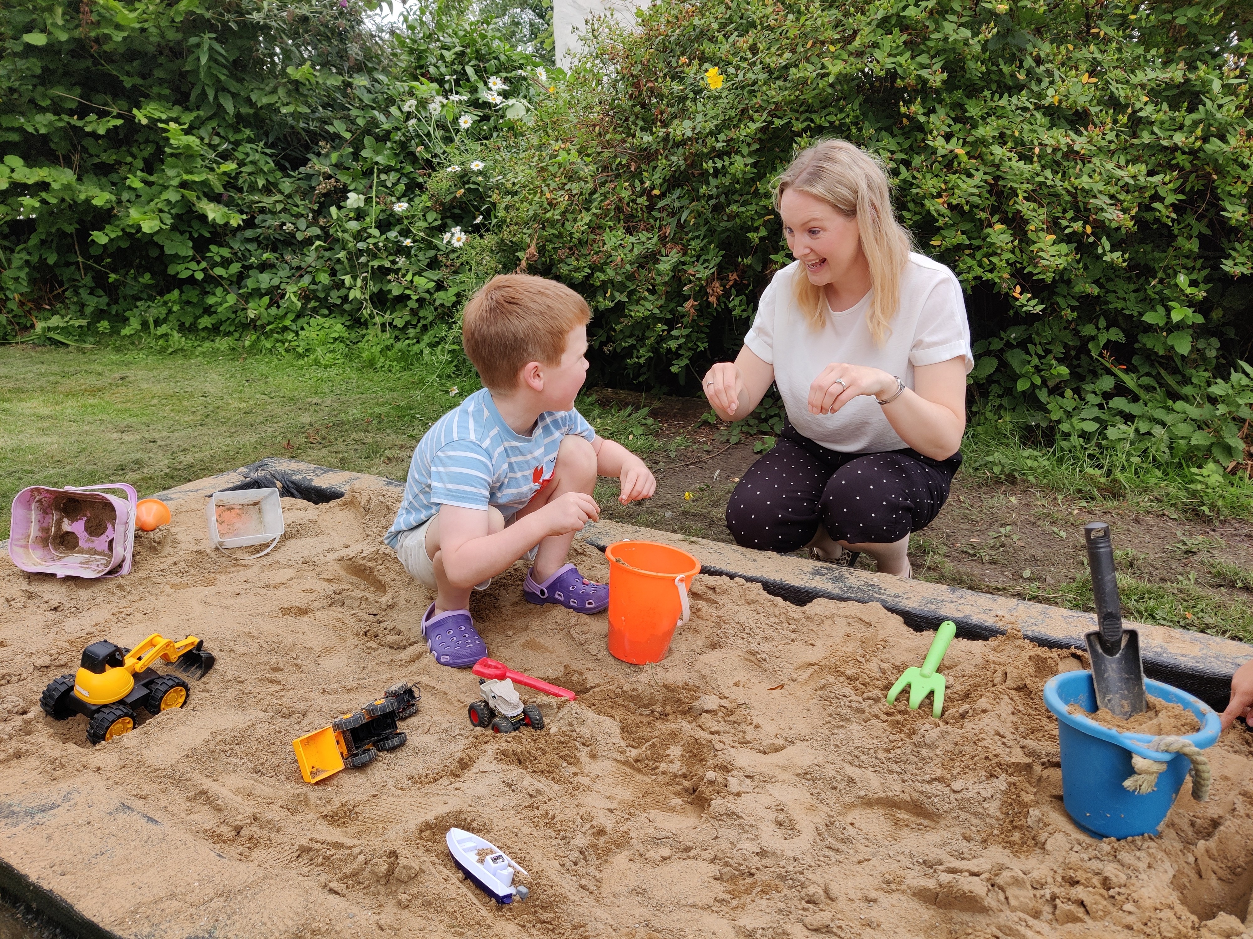 speech therapist and a child signing in a sandpit