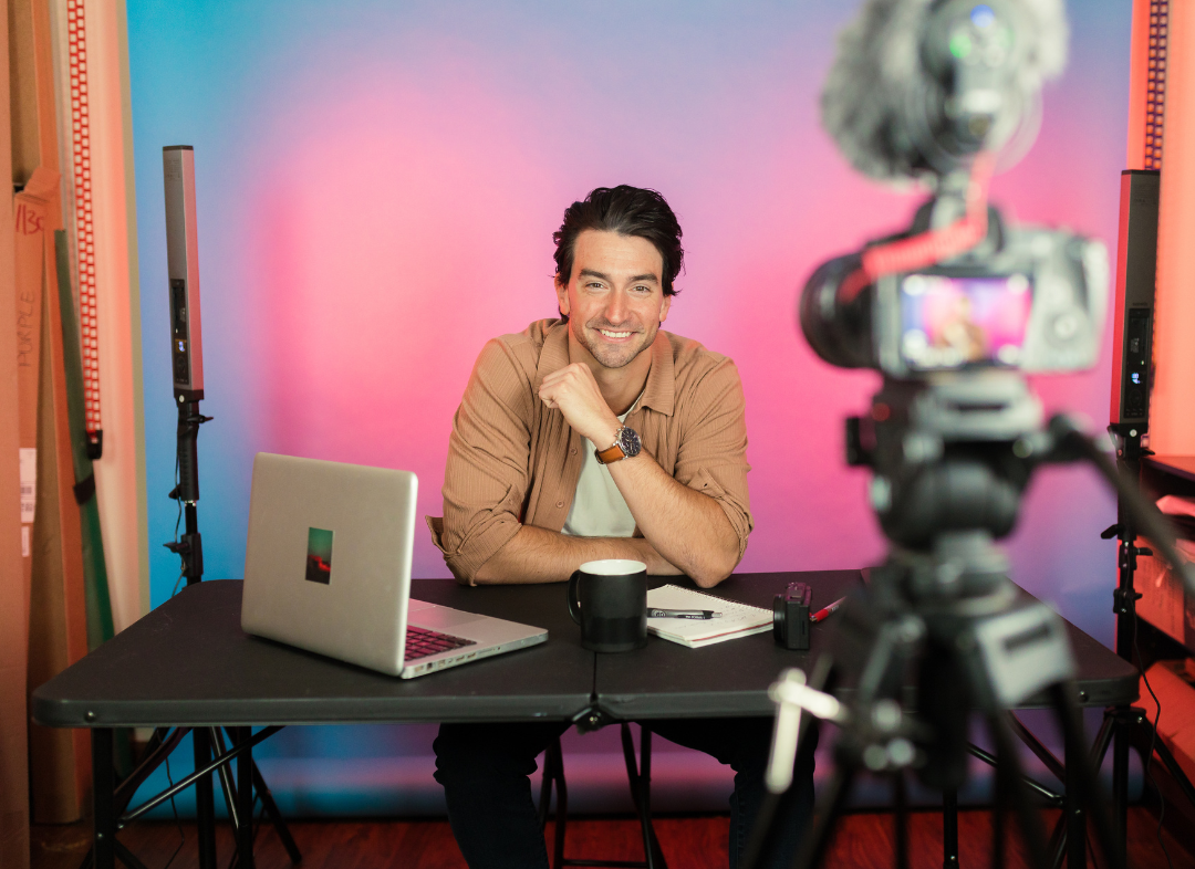 Man smiling during a video recording session in a studio.