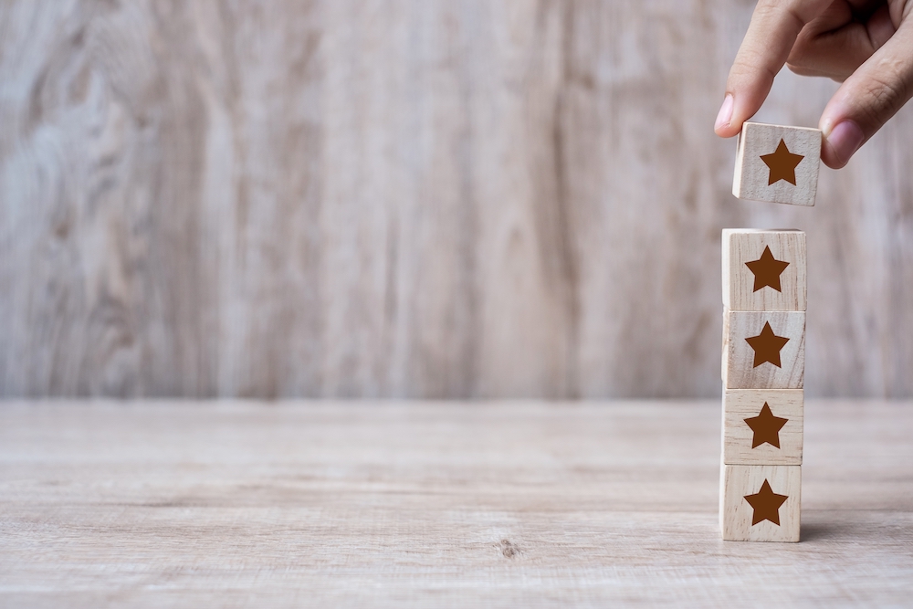 google business profile customer holding wooden blocks with the five star symbol. 