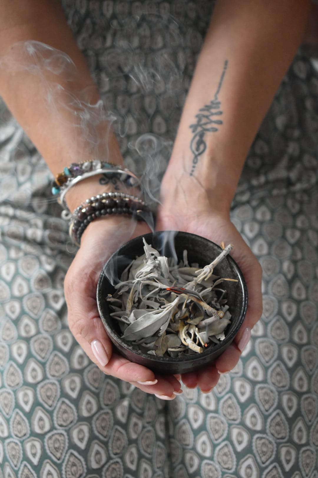 Hands with bracelets and sage