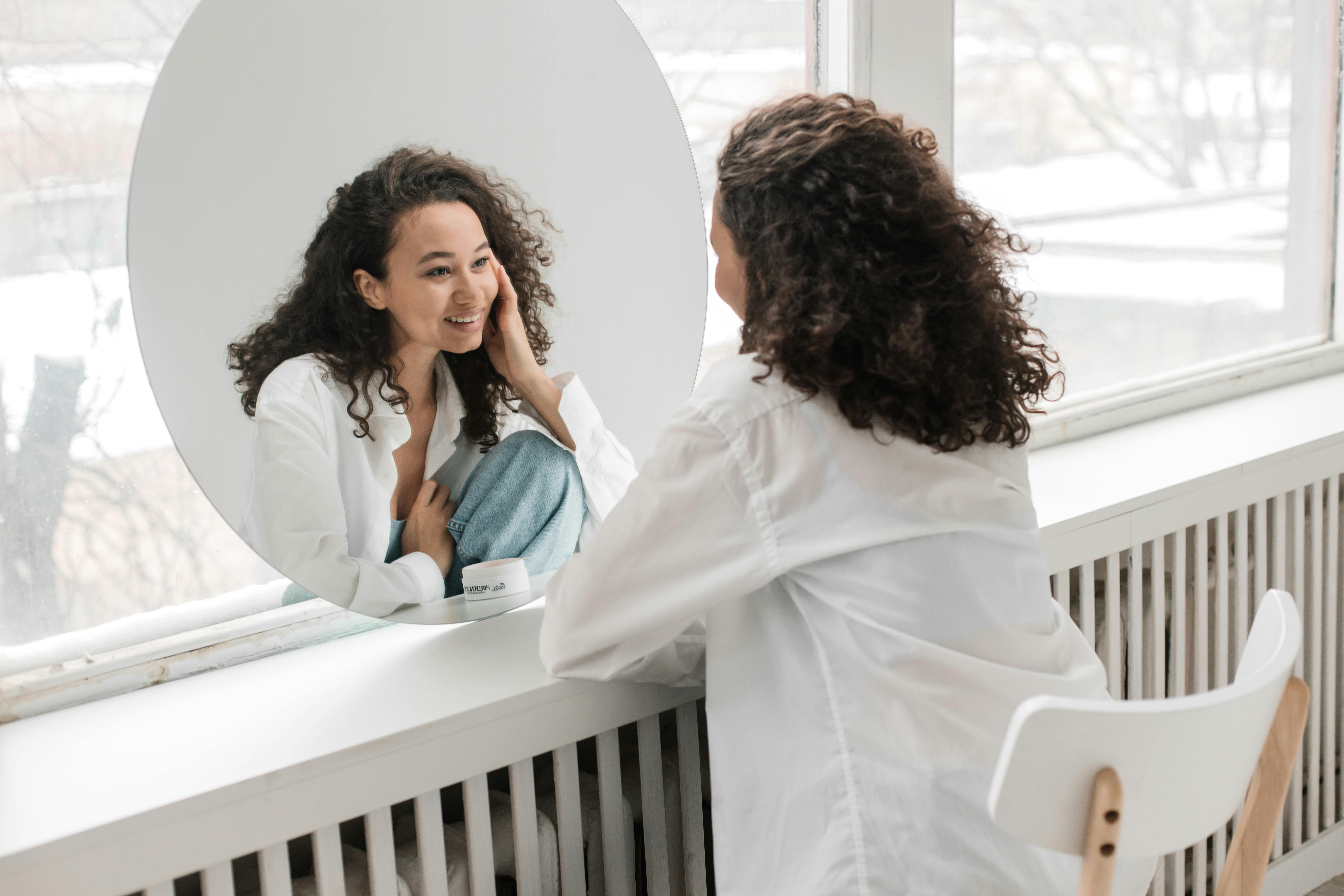 Woman looking at herself in the mirror lovingly