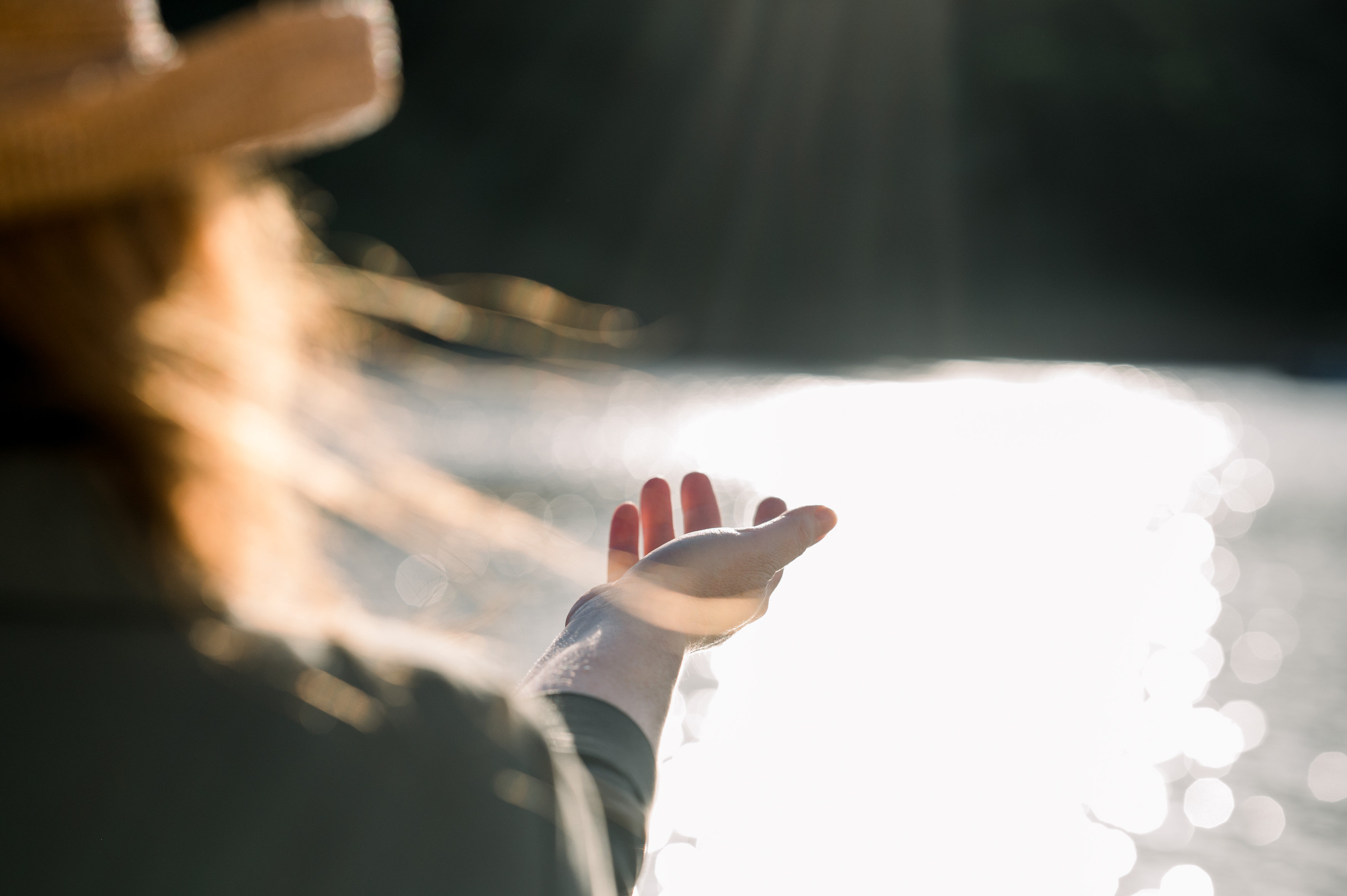 A close-up of an outstretched hand illuminated by sunlight, symbolizing openness and hope. Soft golden light streams through the scene, creating a peaceful and serene atmosphere.