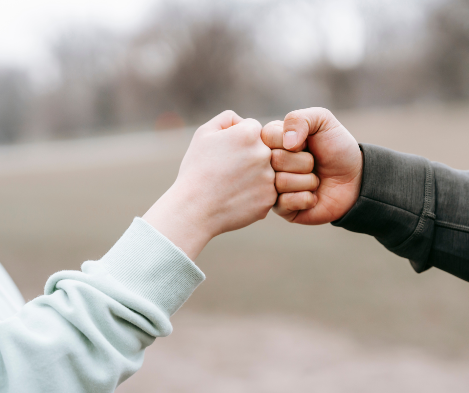 Man and woman fist bumping