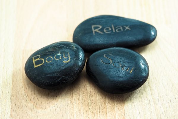 Black stones saying relax, body, and soul.