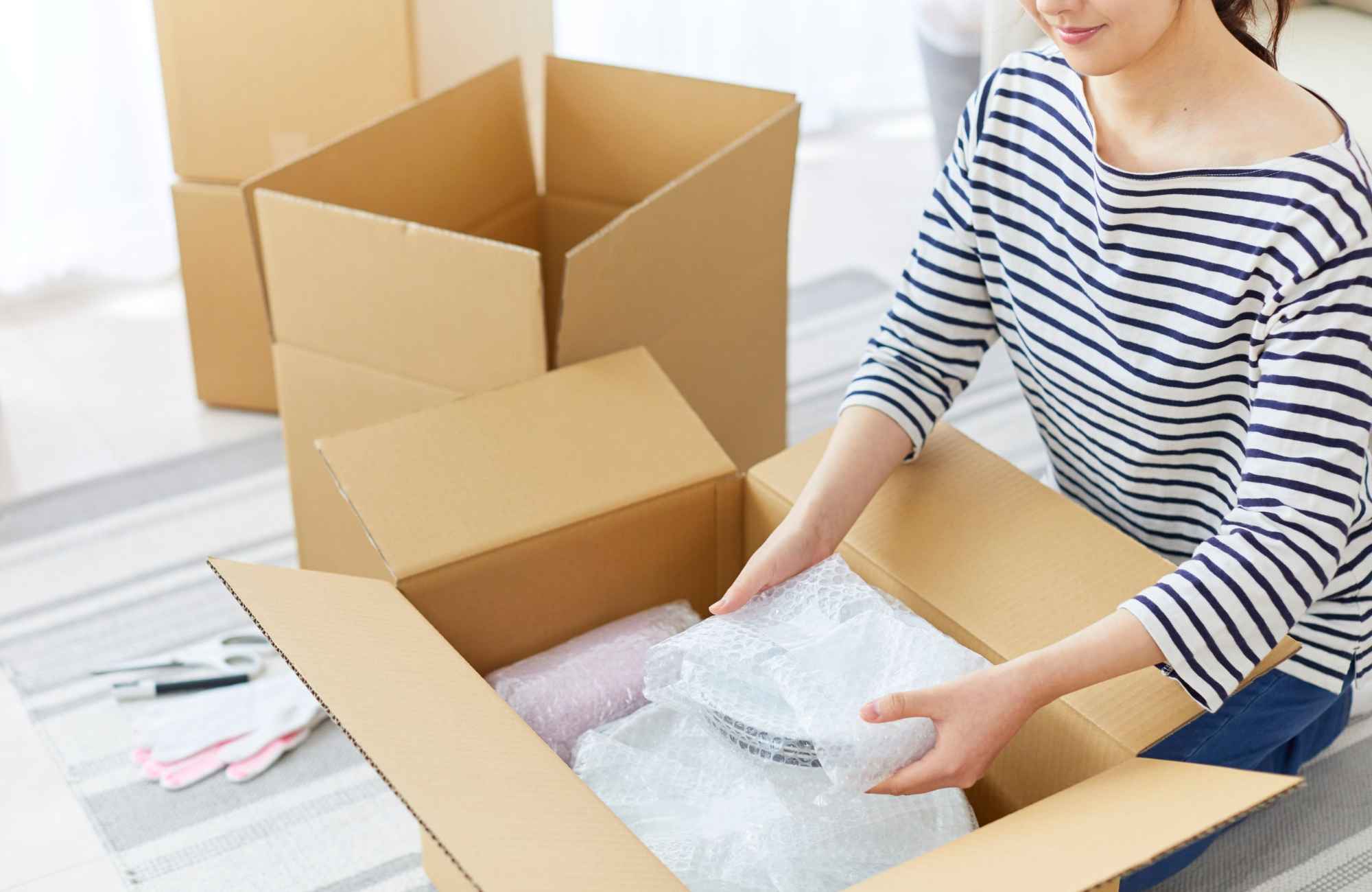 professional-home-organizer-sedona-az-move-management-services-woman-packing-fragile-items-in-box-practical-organizing