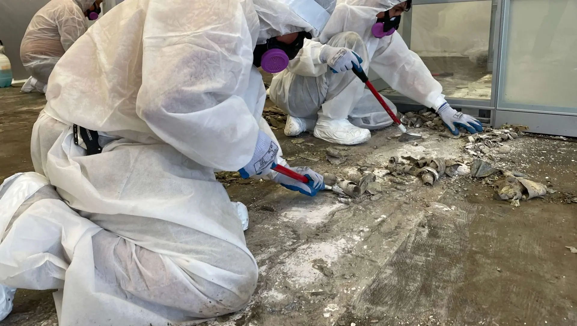 a group of people in white hazmat suits and masks