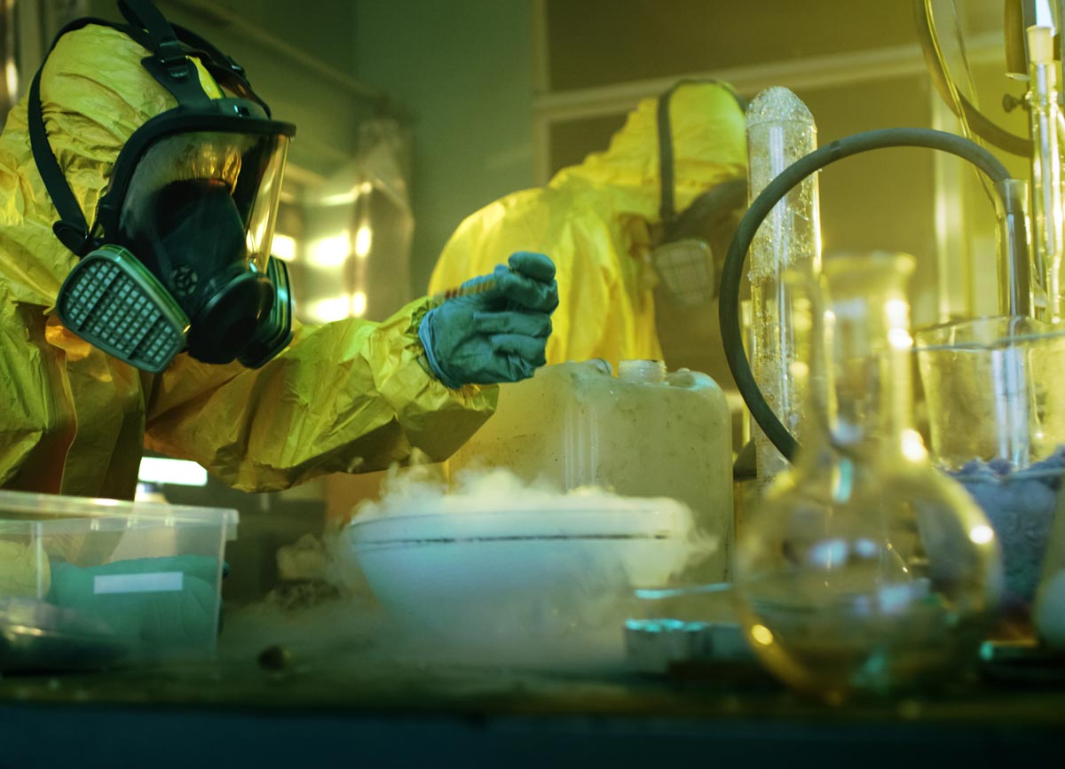 a person in a hazmat suit and mask in a meth lab