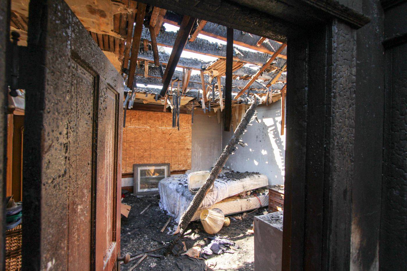 a burned out room with a bed and a fireplace