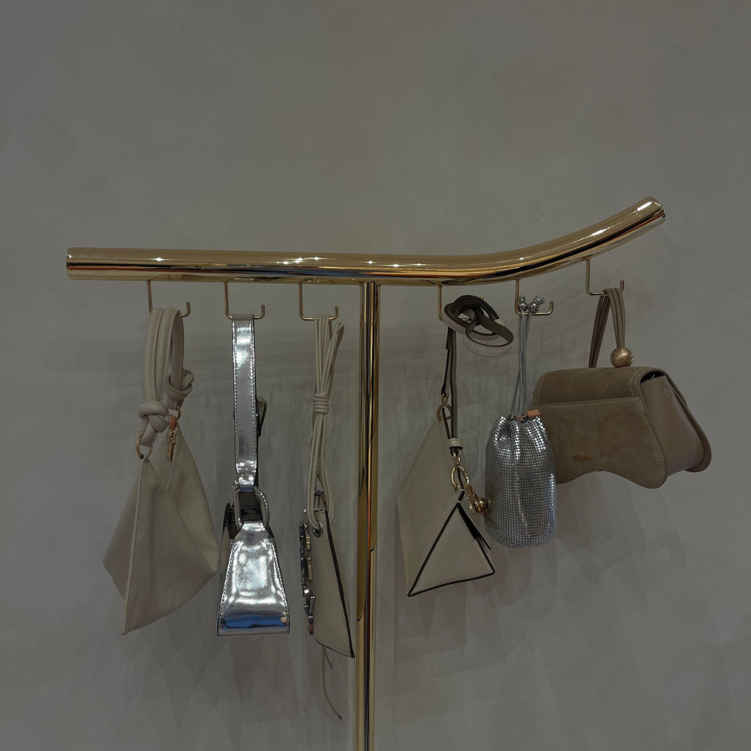 picture full of purses hanging from a gold rod. picture full of purses hanging from a gold rod.