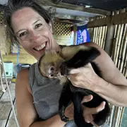 woman smiling holding a monkey