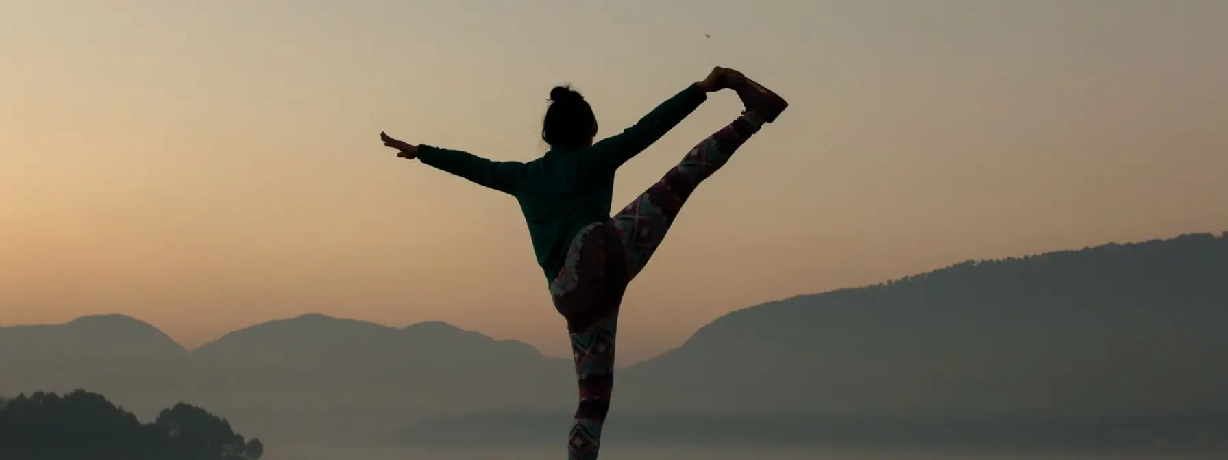 Woman practicing yoga outdoors at sunrise to promote balance, flexibility, and healthy body composition Woman practicing yoga outdoors at sunrise to promote balance, flexibility, and healthy body composition