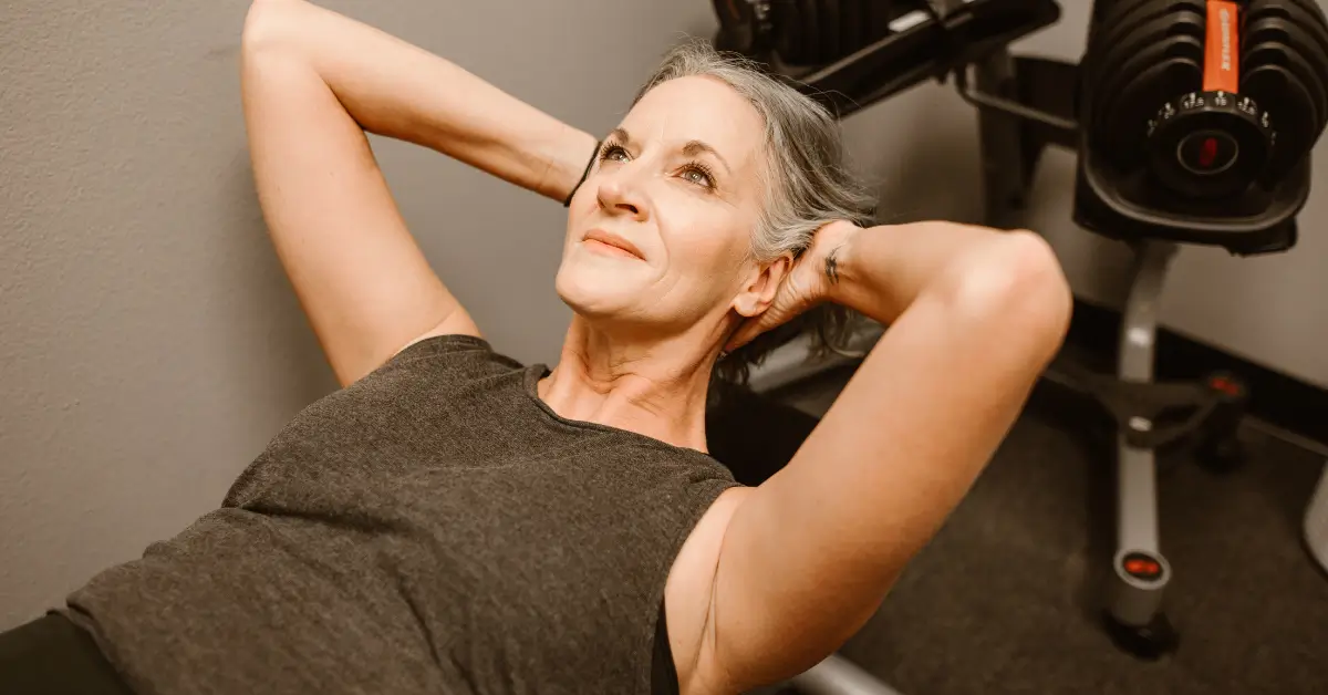 Active middle-aged woman exercising in a gym, highlighting the role of bioidentical testosterone in supporting strength and vitality.