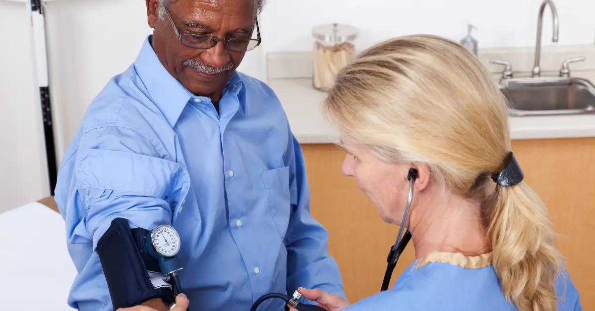 Healthcare provider checking a man's blood pressure during a routine screening, emphasizing the role of preventive care and monitoring in hormone health for adults over 40 in Hurricane, WV