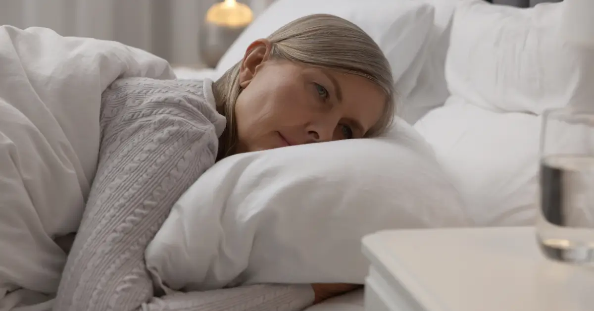 Middle-aged woman lying awake in bed, reflecting common sleep disturbances that preventive hormone care and lifestyle adjustments can help address for women over 40 in Hurricane, WV