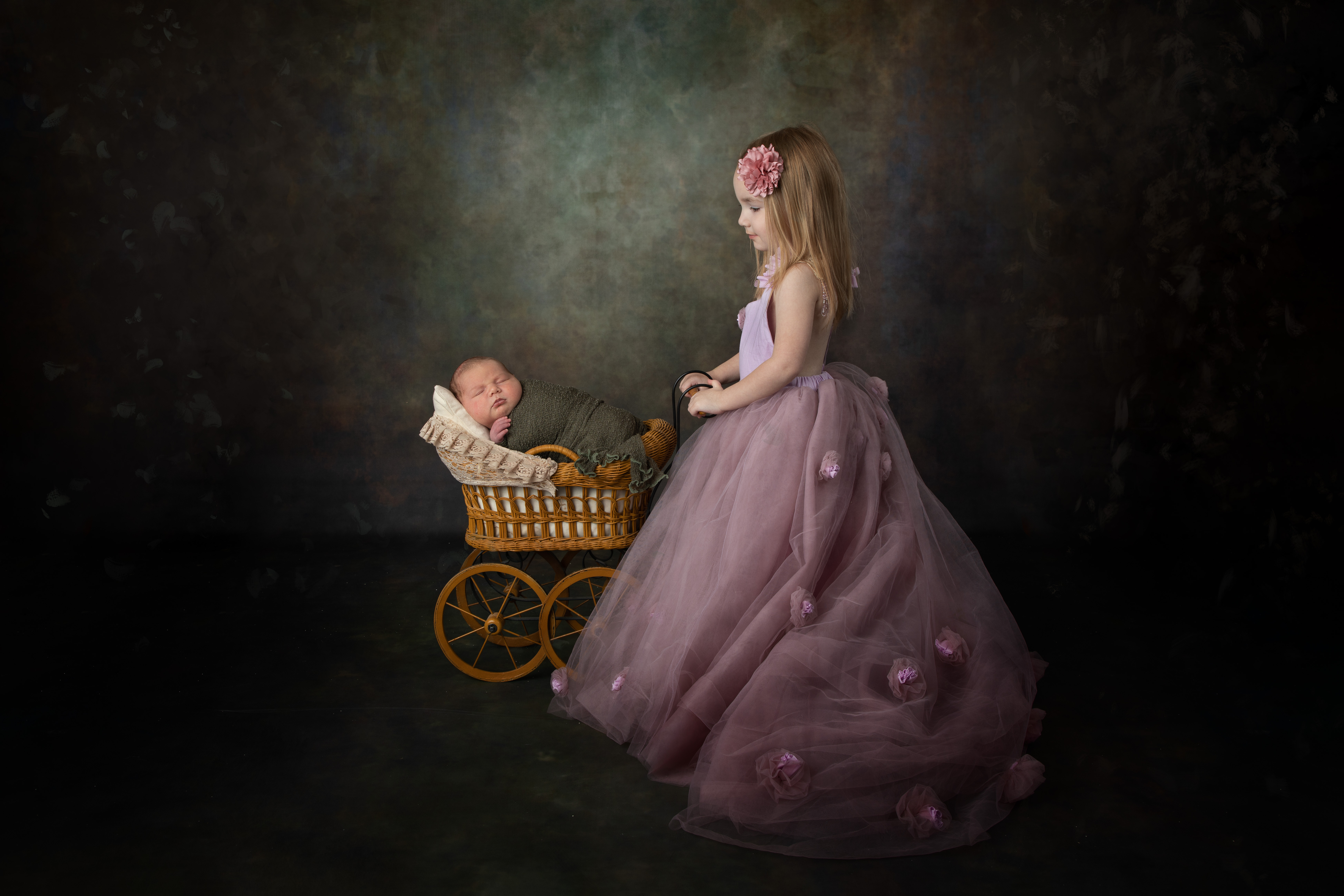 Rowan poses with her baby brother in an antique doll carriage