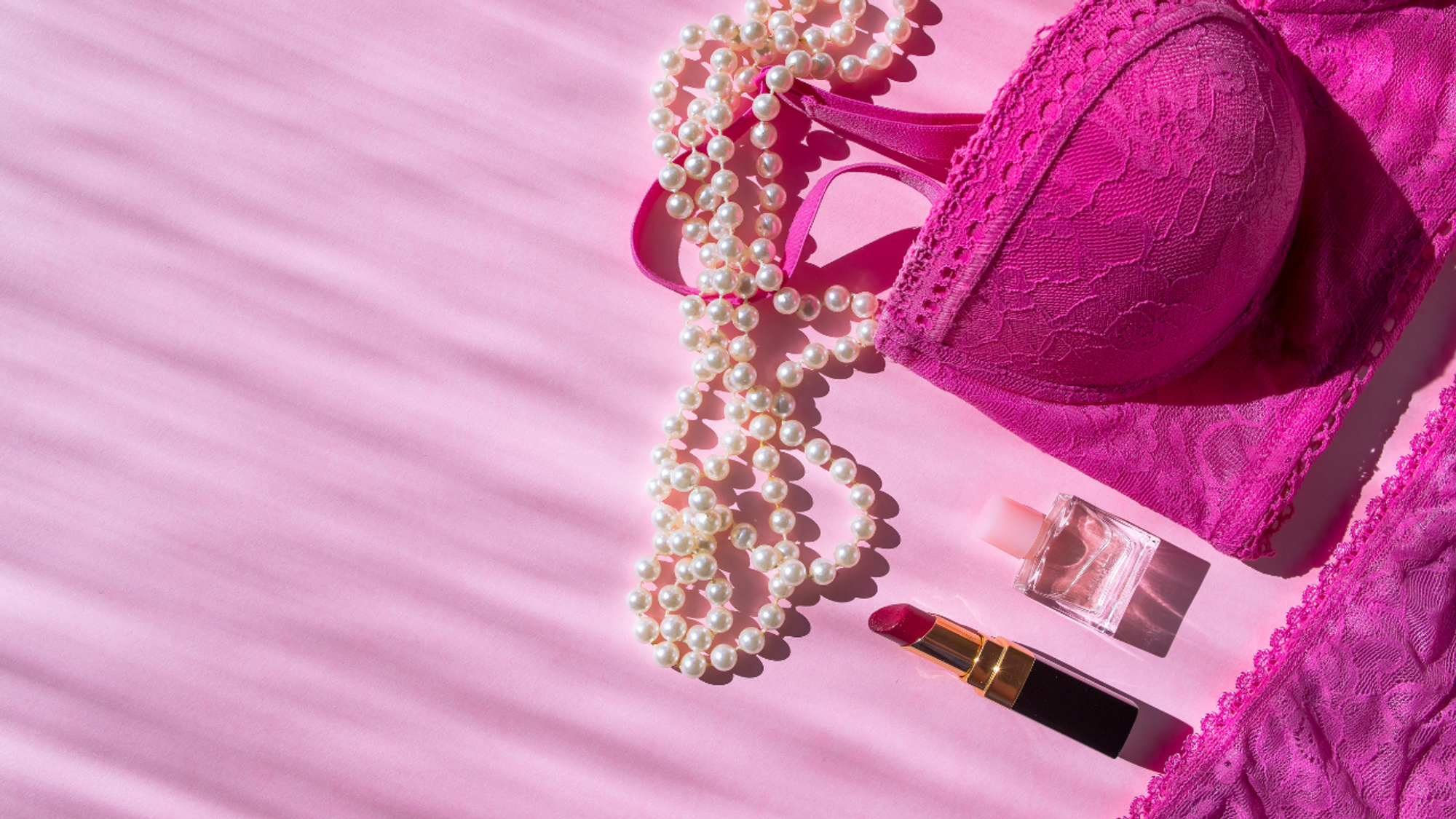 Pink bra and white beads on a pink background