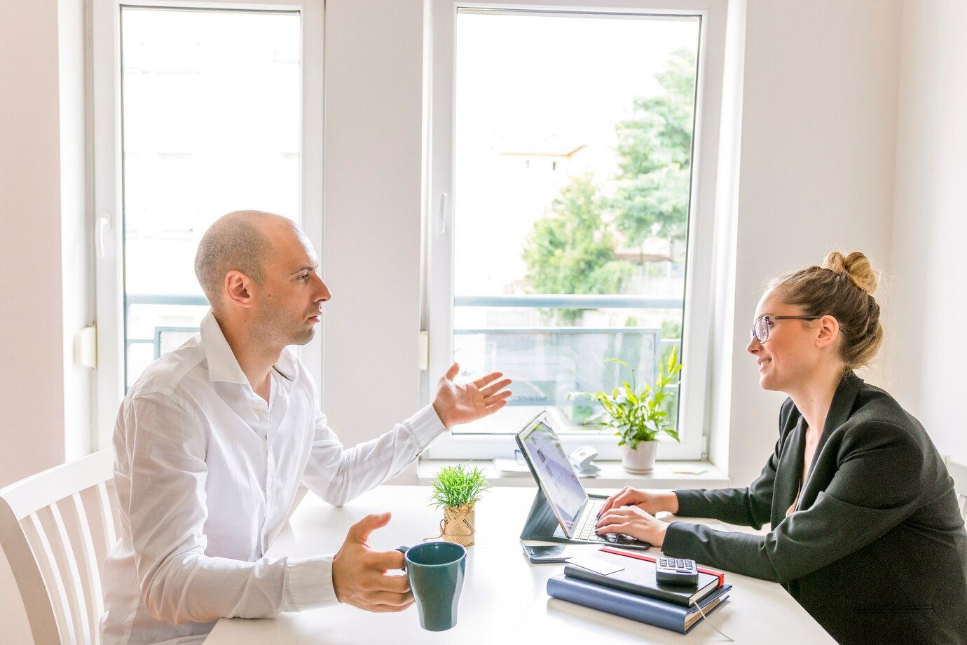 Man and woman talking to each other - hybrid work one on one meeting Man and woman talking to each other - hybrid work one on one meeting
